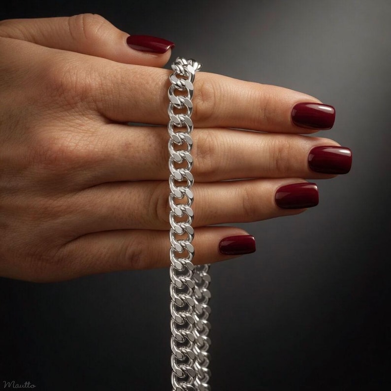 Silver fancy link chain straps for purses, handbags of all sizes and styles and phone cases. Shown on a hand model.