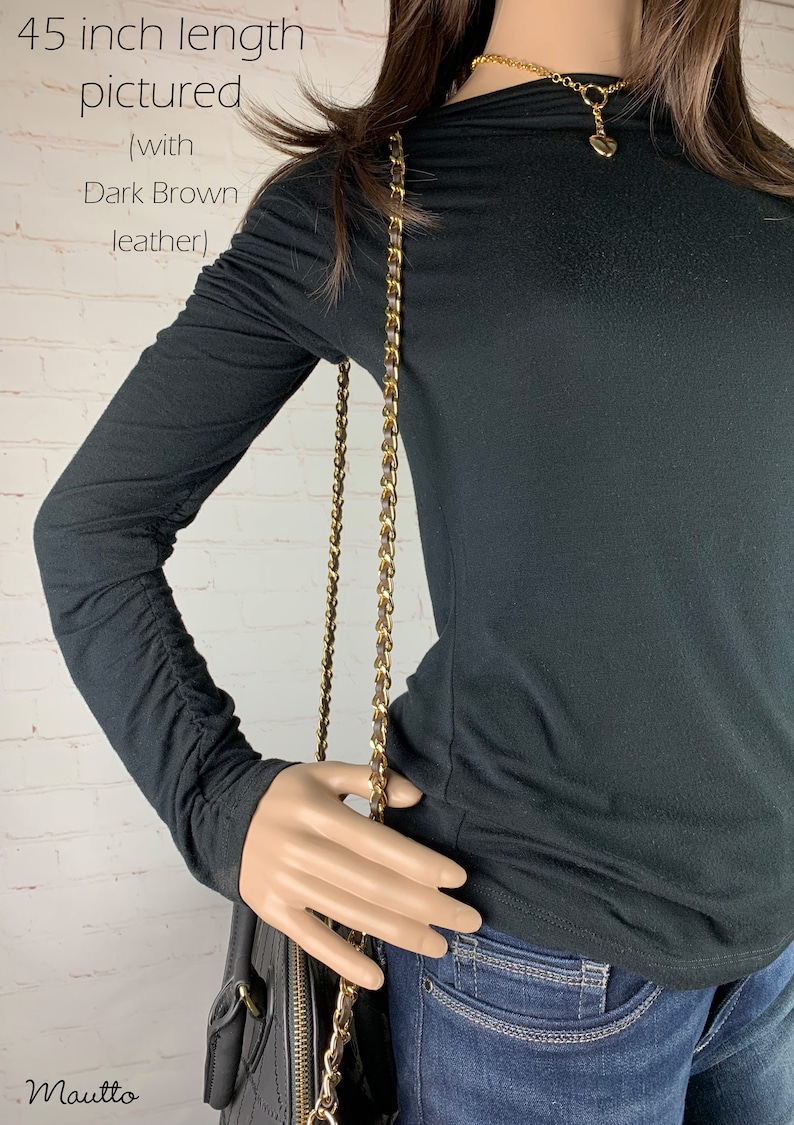 Photo of mannequin with long shoulder strap on handbag.