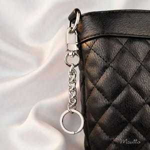 Silver purse accessory to tether keys safely to your bag. Includes keyring and swivel clip.