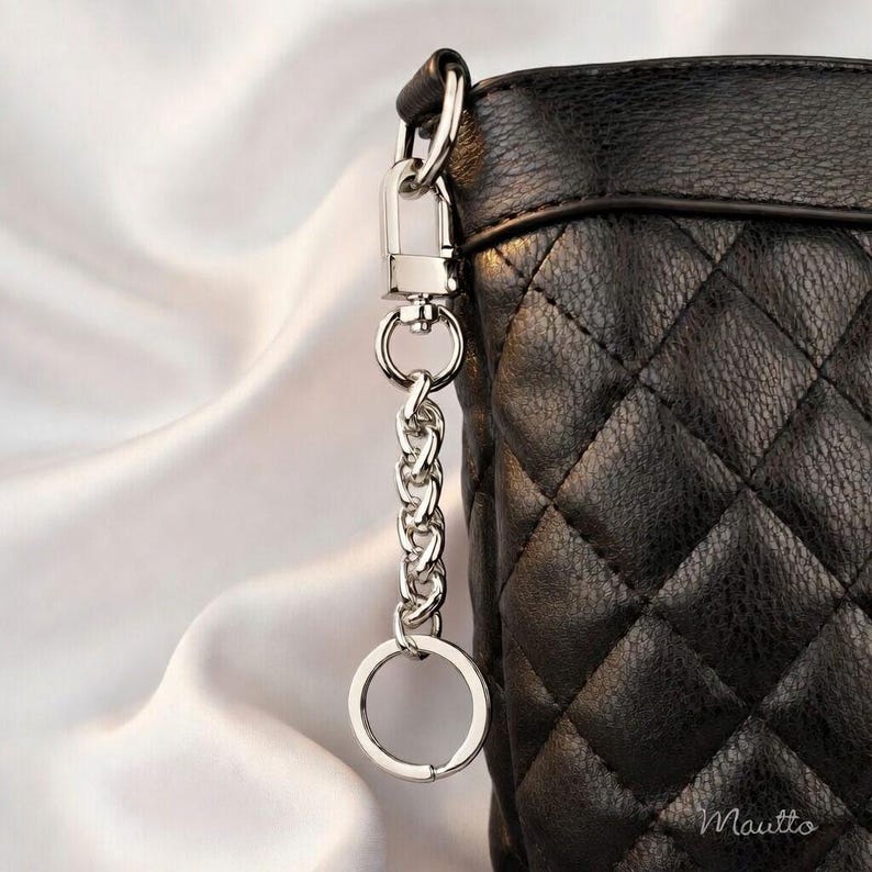 Silver purse accessory to tether keys safely to your bag. Includes keyring and swivel clip.