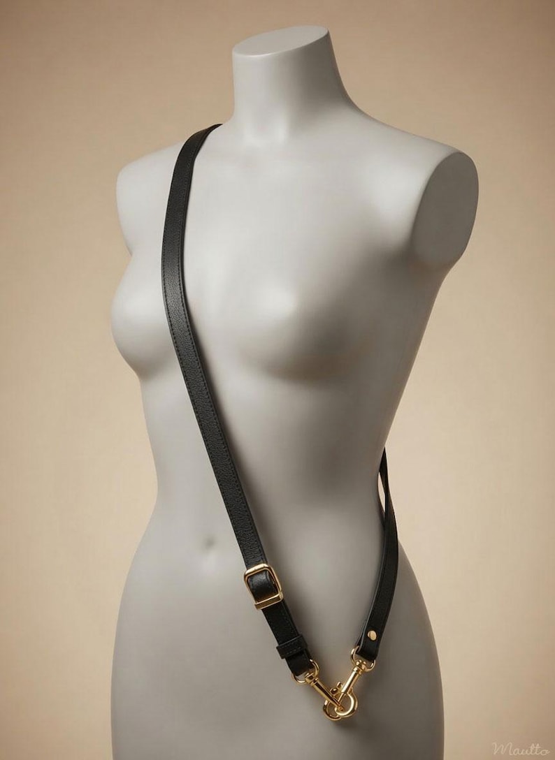 Black pebbled leather cross body length strap, in an adjustable configuration, shown on a mannequin.