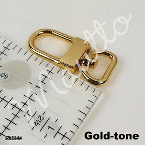 Gold-tone clip for leather wrist strap.