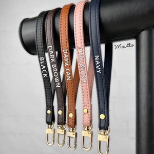 Photo of petite leather wrist strap key chain accessories, in black, dark brown, dark tan patina, pink blush and navy leather colors (on photo).