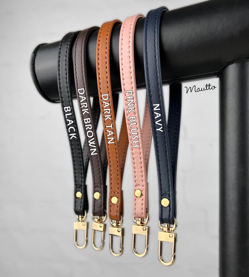 Photo of petite leather wrist strap key chain accessories, in black, dark brown, dark tan patina, pink blush and navy leather colors (on photo).