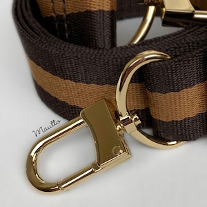 Photo of DE colorway fabric strap with gold clips/hardware.