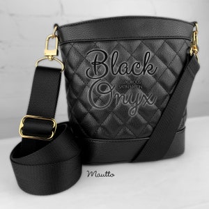 Photo of black woven purse strap on purse. Adjustable shoulder to cross body length.