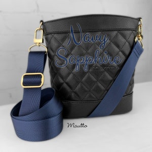 Photo of navy woven purse strap on purse. Adjustable shoulder to cross body length.