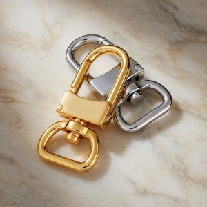 Luggage tag clips with swiveling base so luggage tag lays flat on bag or suitcase. Gold or silver available. Handbag or travel accessory. Alternate view.