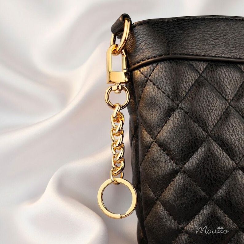 Gold purse accessory to tether keys safely to your bag. Includes keyring and swivel clip.