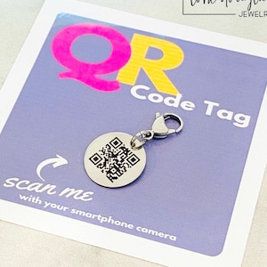 以下が含まれることがあります： ピンクと黄色のQRコードタグがついた白いカード。カードには「スマートフォンカメラでスキャンしてください」と「lora douglas JEWELLERY」と書かれています。