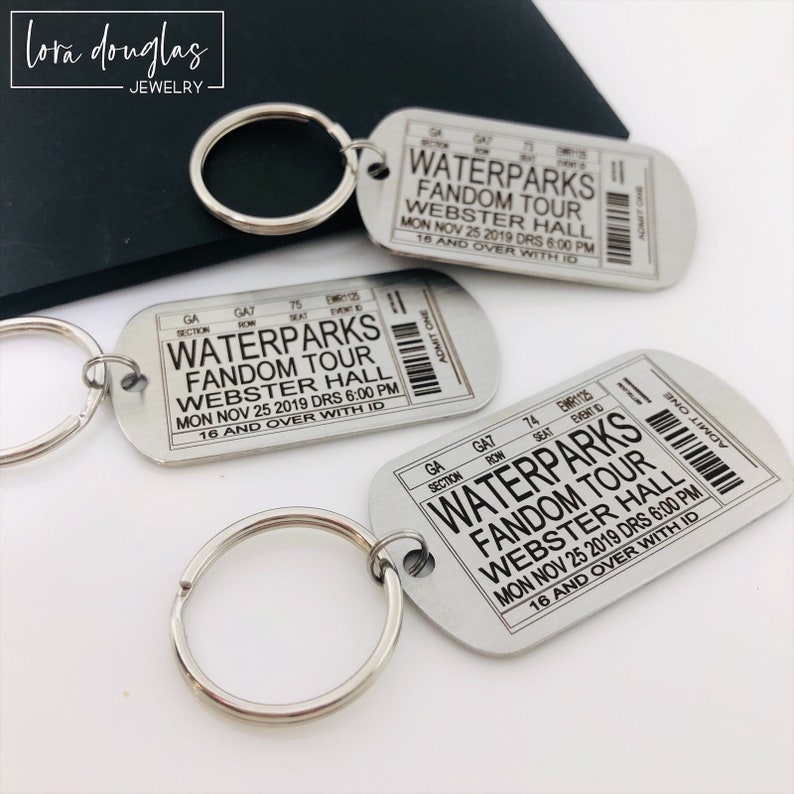 K&ouml;nnte beinhalten: Silberner Schl&uuml;sselanh&auml;nger mit einem ticketf&ouml;rmigen Anh&auml;nger, auf dem steht "Waterparks Fandom Tour Webster Hall Mo 25. Nov 2019 Drs 18:00 Uhr 16 Jahre und &auml;lter mit Ausweis".