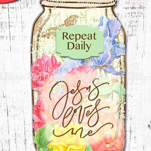 Op de afbeelding: Een kaart in de vorm van een weckpot met een bloemmotief van roze, gele en blauwe bloemen. De tekst "Repeat Daily" staat op een lichtgroen label en de tekst "Jesus loves me" is gecentreerd over de kleurrijke bloemenillustratie geplaatst.
