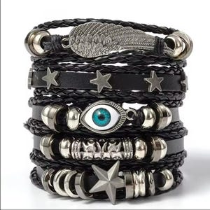 May include: A stack of black leather bracelets with silver-toned accents. The bracelets feature braided leather, star charms, an eye charm with a blue iris, and a wing charm. The bracelets are stacked together.