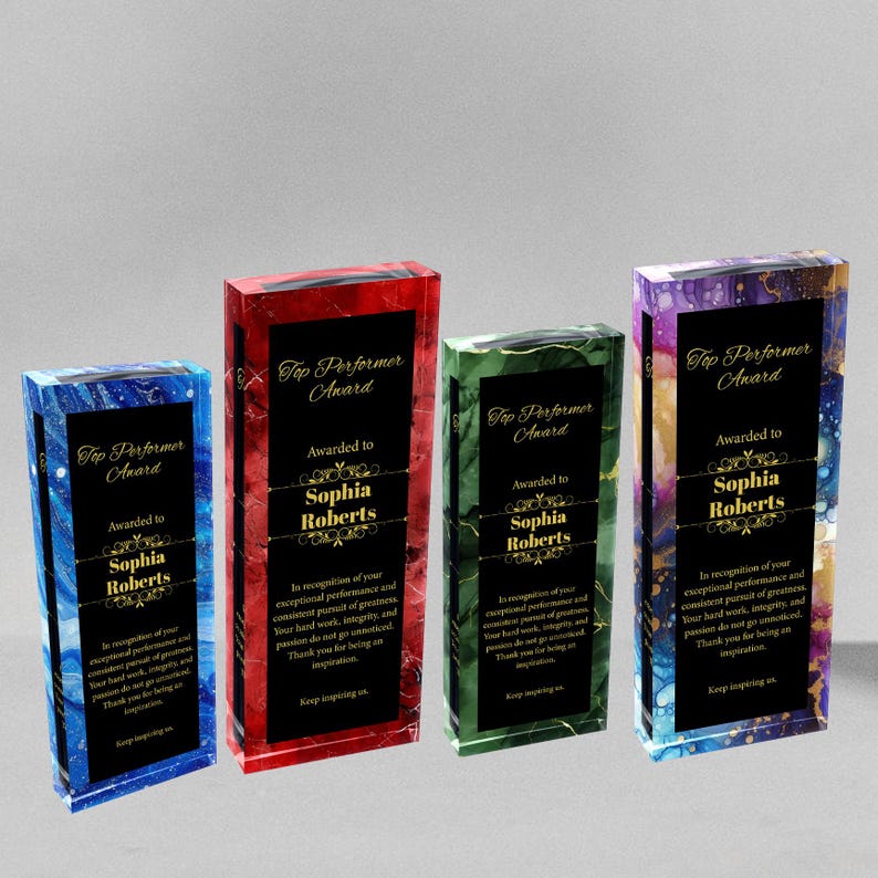 K&ouml;nnte beinhalten: Vier gl&auml;serne Auszeichnungsplatten mit schwarzem Rand und goldenen Schriftz&uuml;gen. Jede Platte hat eine andere Hintergrundfarbe: blau, rot, gr&uuml;n und lila. Der Text auf den Platten lautet "Top Performer Award" und "Awarded to Sophia Roberts".