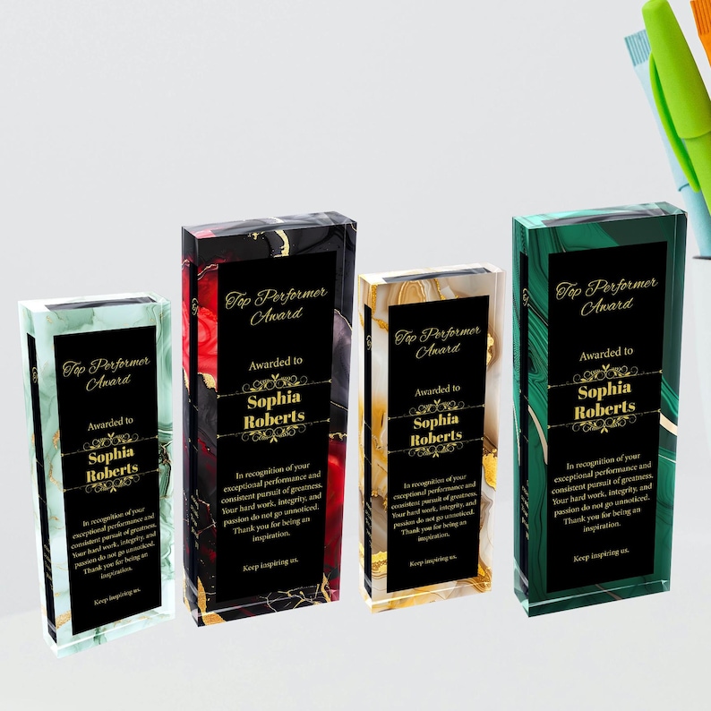 K&ouml;nnte beinhalten: Vier Glasplaketten mit schwarzen, goldenen, gr&uuml;nen und roten Marmormustern. Jede Plakette tr&auml;gt eine goldene Aufschrift "Top Performer Award" und "Awarded to Sophia Roberts". Der Text unter dem Namen lautet "In Anerkennung Ihrer au&szlig;ergew&ouml;hnlichen Leistung und Ihres best&auml;ndigen Strebens nach Gr&ouml;&szlig;e. Ihre harte Arbeit, Integrit&auml;t und Leidenschaft bleiben nicht unbemerkt. Vielen Dank, dass Sie eine Inspiration sind. Inspirieren Sie uns weiter."