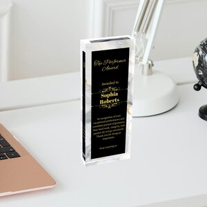 K&ouml;nnte beinhalten: Eine schwarze und wei&szlig;e Marmor-Muster-Acrylauszeichnung mit goldenen Schriftz&uuml;gen. Die Plakette tr&auml;gt die Aufschrift "Top Performer Award" und "Awarded to Sophia Roberts". Die Plakette enth&auml;lt auch eine Anerkennung f&uuml;r au&szlig;ergew&ouml;hnliche Leistungen und die konsequente Verfolgung von Gr&ouml;&szlig;e.