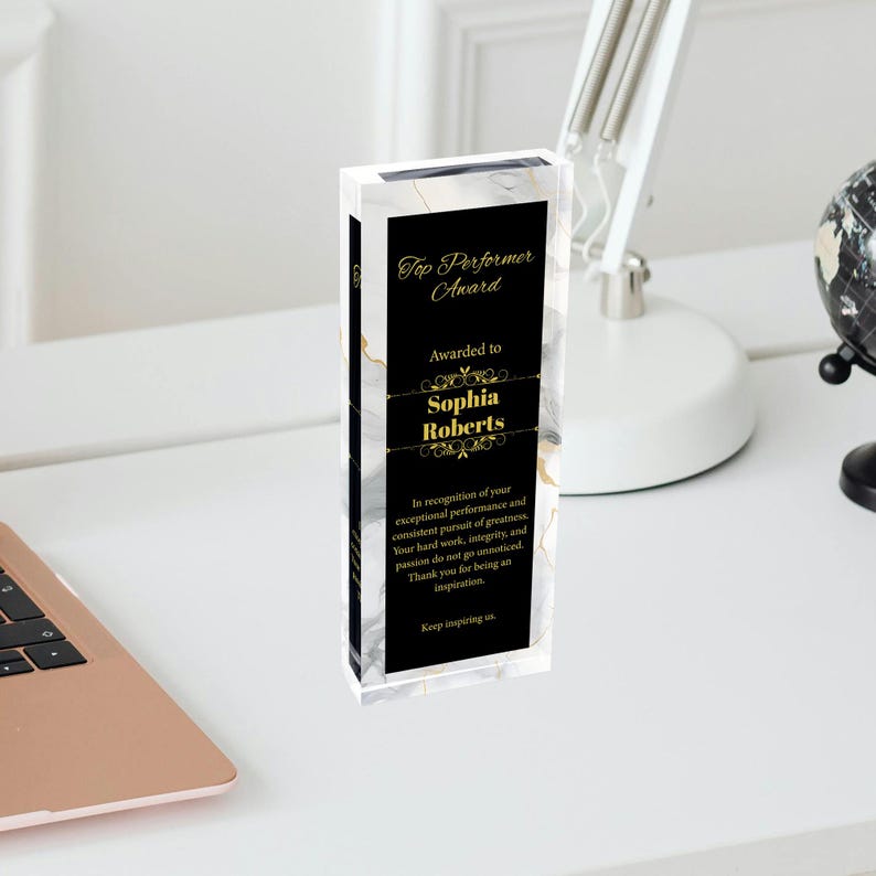K&ouml;nnte beinhalten: Eine schwarze und wei&szlig;e Marmor-Muster-Acrylauszeichnung mit goldenen Schriftz&uuml;gen. Die Plakette tr&auml;gt die Aufschrift "Top Performer Award" und "Awarded to Sophia Roberts". Die Plakette enth&auml;lt auch eine Anerkennung f&uuml;r au&szlig;ergew&ouml;hnliche Leistungen und die konsequente Verfolgung von Gr&ouml;&szlig;e.