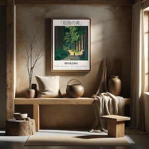 Puede incluir: Un p&oacute;ster minimalista con una escena de paisaje japon&eacute;s de un camino a trav&eacute;s de un bosque. El p&oacute;ster se titula "La belleza de la soledad" y presenta el texto "Miyazaki" en negrita. El p&oacute;ster est&aacute; enmarcado y colgado en una pared en una habitaci&oacute;n con un banco de madera y un jarr&oacute;n con una rama.