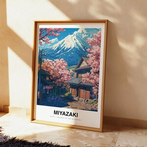 May include: Framed art print featuring a Japanese landscape with Mount Fuji in the background. The artwork depicts traditional buildings, cherry blossom trees, and the word "Miyazaki" at the bottom. The color palette includes blues, pinks, and browns.