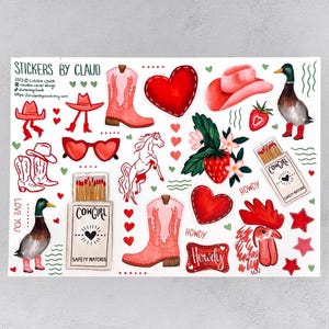 May include: A sheet of watercolour stickers featuring cowboy boots, hats, hearts, a horse, a duck, and matches. The stickers are in shades of red, pink, and white, with the text "Cowgirl", "Howdy", and "Love You".