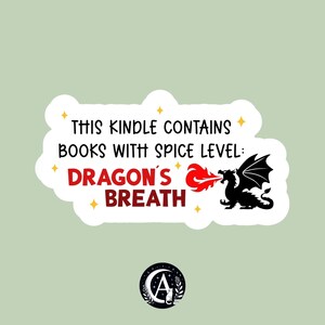 Könnte beinhalten: Weißer Aufkleber mit dem Text: "THIS KINDLE CONTAINS BOOKS WITH SPICE LEVEL: DRAGON'S BREATH." Ein schwarzer Drache speit rotes Feuer. Der Aufkleber hat einen hellgrünen Hintergrund und ein rundes Logo.