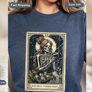 May include: Heather dark gray t-shirt featuring a tarot card design. The card depicts a skeleton with long hair holding a snake, with the text "THE BALL PYTHON MOM". The design has a vintage, distressed look.