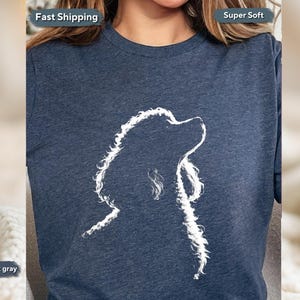 May include: Heather dark gray t-shirt featuring a white outline of a dog's head and neck. The dog is looking upwards. The shirt has the words "Fast Shipping" and "Super Soft" printed on it.