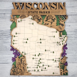 May include: A wooden map of Wisconsin with the text "Wisconsin State Parks" at the top. The map is decorated with purple flowers, green trees, and a deer. The map shows the locations of all the state parks in Wisconsin.