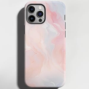 Può includere: Custodia per smartphone con un design marmorizzato pastello nei toni del rosa, bianco e blu. La custodia ha una finitura lucida e un modulo fotocamera nero. L'estetica generale è moderna e minimalista.