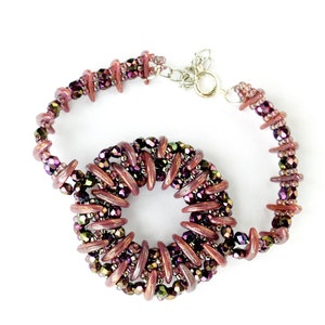May include: A purple and brown beaded bracelet with a circular design. The bracelet is made with small, iridescent beads and has a silver clasp.