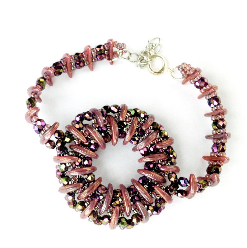 May include: A purple and brown beaded bracelet with a circular design. The bracelet is made with small, iridescent beads and has a silver clasp.