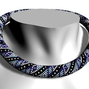 May include: A black, white, and blue beaded necklace with a geometric pattern. The necklace is made of small, round beads and is worn on a mannequin.