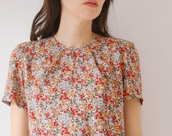 Women's printed floral viscose blouse. Round crew neckline with pleats. Back pleat. Yoke. Short sleeves. Square fit