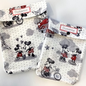 Può includere: Due pochette in tessuto bianco a pois con i personaggi di Topolino e Minnie Mouse. Le pochette hanno una patta con chiusura a bottone e un'etichetta con il nome personalizzata che dice "Susanne".