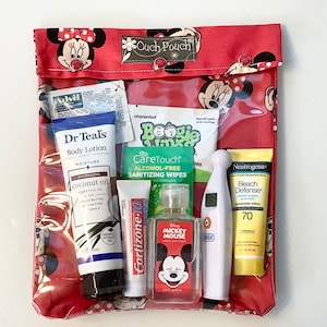 Könnte beinhalten: Eine durchsichtige Plastiktasche in Rot und Weiß mit Mickey-Mouse-Motiv, die verschiedene Erste-Hilfe- und Hygieneartikel enthält, darunter Sonnencreme, Händedesinfektionsmittel, Lotion, Feuchttücher und ein Thermometer. Die Tasche trägt den Schriftzug "Ouch Pouch" auf der Vorderseite.