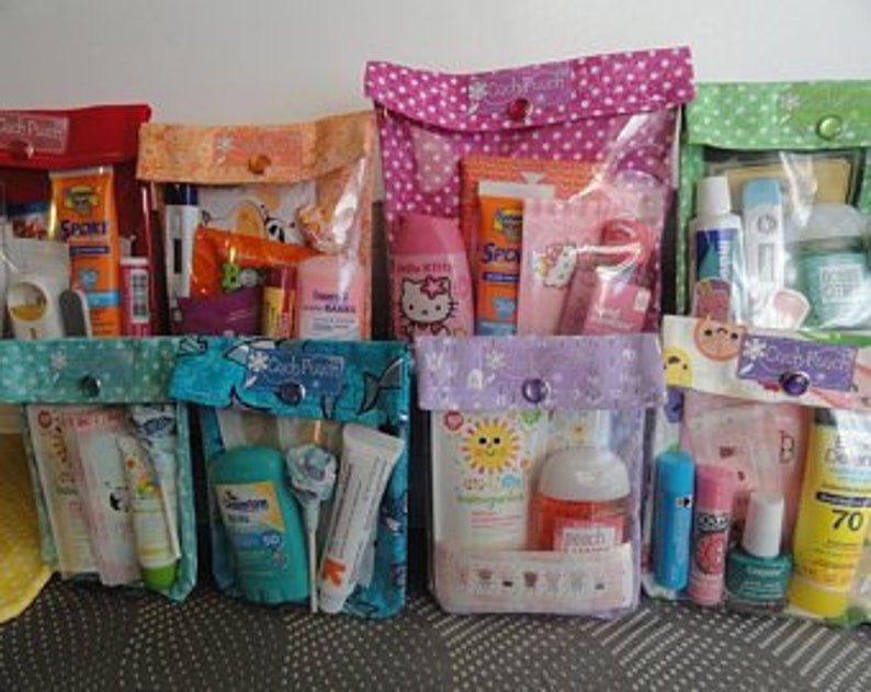 May include: Seven colorful zippered pouches with clear vinyl windows, each filled with various travel-sized toiletries and personal care items. The pouches are decorated with different patterns and designs.