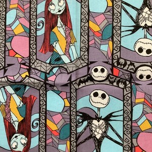 May include: A colorful fabric with a repeating pattern of stained glass windows featuring Jack Skellington and Sally from the Nightmare Before Christmas. The characters are surrounded by bats and spiderwebs.