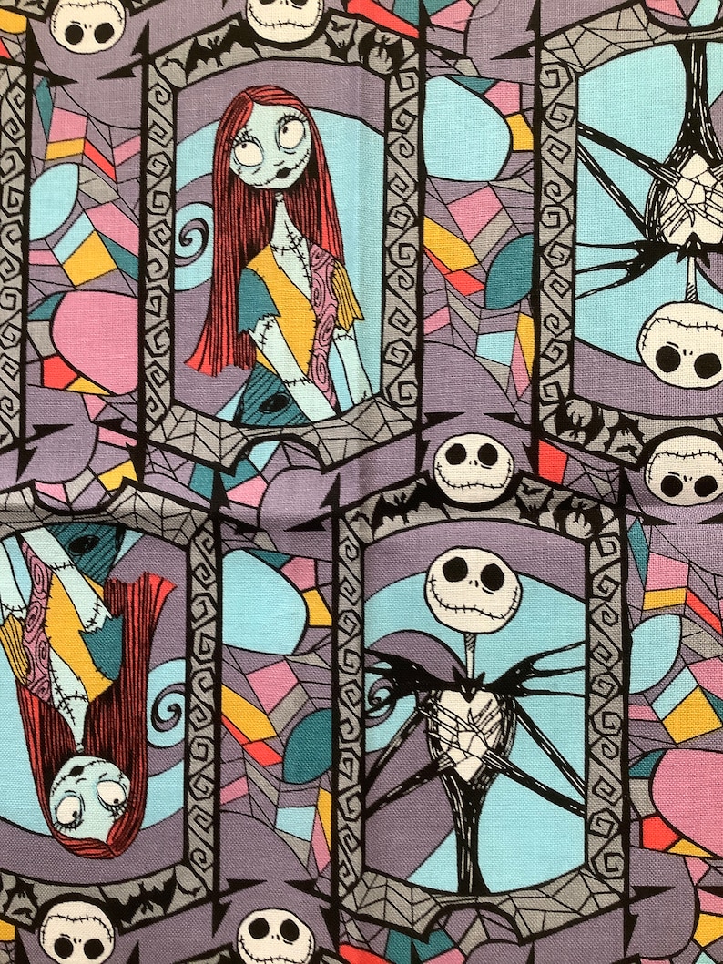 May include: A colorful fabric with a repeating pattern of stained glass windows featuring Jack Skellington and Sally from the Nightmare Before Christmas. The characters are surrounded by bats and spiderwebs.