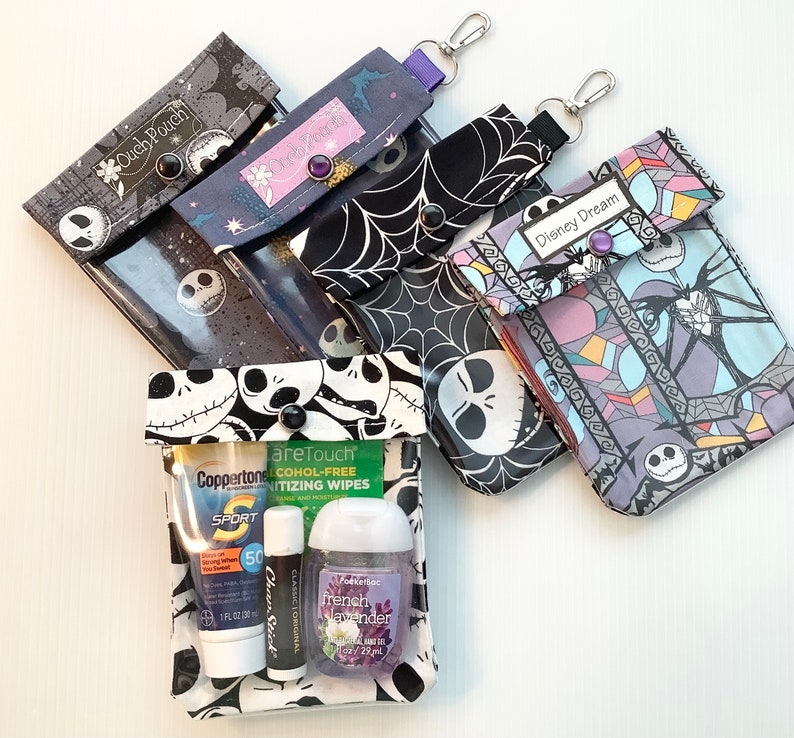 Puede incluir: Cuatro bolsas con cremallera de tem&aacute;tica Nightmare Before Christmas en blanco y negro con ventanas de vinilo transparente. Las bolsas est&aacute;n etiquetadas como "Ouch Pouch", "Disney Dream" y "areTouch". Las bolsas contienen desinfectante de manos, protector solar y toallitas desinfectantes.