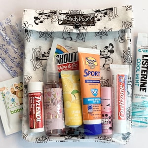 Könnte beinhalten: Eine weiße Keramik-Tasse mit schwarzem Henkel und dem Text "But First, Coffee" in fetter, schwarzer Schrift. Die Tasse steht vor einem verschwommenen Hintergrund, der eine gemütliche Umgebung suggeriert.