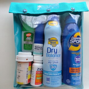 May include: A clear pouch with a teal top, containing various health and personal care items. Includes sunscreen, insect repellent, allergy medication, and cold relief medicine. The pouch is approximately 8 inches wide.