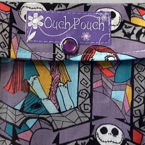 May include: A purple fabric pouch with a Nightmare Before Christmas print. The pouch has a purple label that says "Ouch-Pouch" and a purple button.