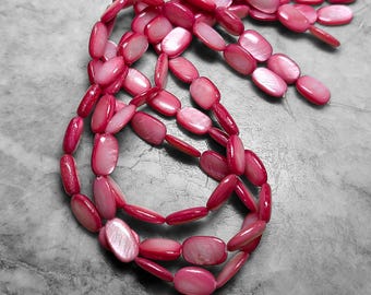 May include: A necklace composed of pink, oval-shaped beads. The beads have a glossy finish and are strung together, forming a layered design. The necklace is displayed on a gray surface, showcasing its color and texture.