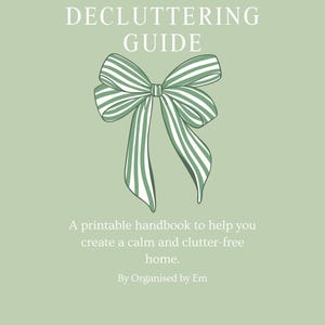 May include: A handbook titled "The Decluttering Guide" with a green and white striped bow illustration on a pale green background. The text promises to help create a calm, clutter-free home. Includes "Decluttering tips" and "Free printable checklists".