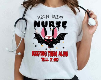 May include: White t-shirt with a black bat graphic and the text "Night Shift Nurse Keeping Them Alive Till 7:05".