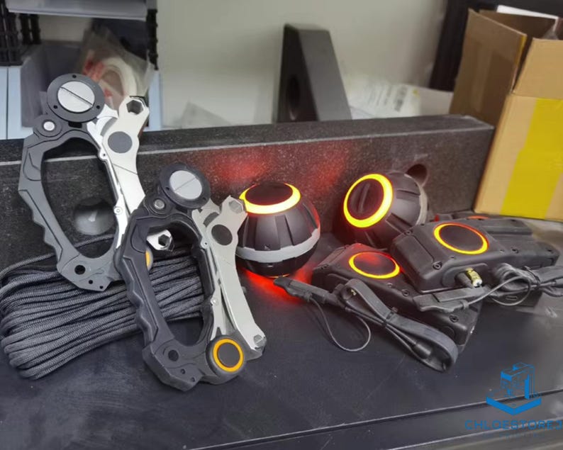 May include: Two black and silver utility tools with orange accents, a black and orange device with a red light, and two black and orange devices with red lights.