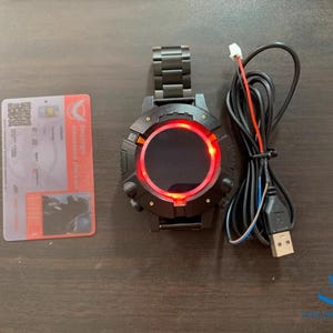 May include: A black smartwatch with a red digital display and a USB charging cable. The watch has a metal band and a round face.