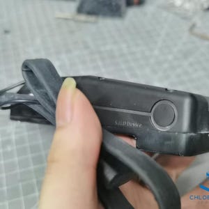 May include: A black 3D printer filament spool holder with a black rubber strap. The holder has a label that reads "S.I.I.P Device".
