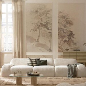 May include: A contemporary living room with a cream modular sofa, a round glass coffee table, and a beige rug. The room features large wall art with tree illustrations and neutral-toned curtains.