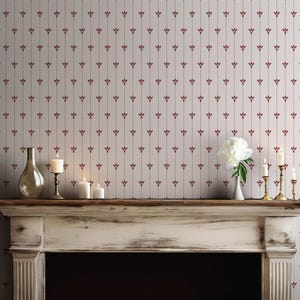 May include: A fireplace mantel with candles, a vase, and a white flower arrangement. The wall behind the mantel is covered in wallpaper with a repeating pattern of vertical lines and burgundy floral accents.